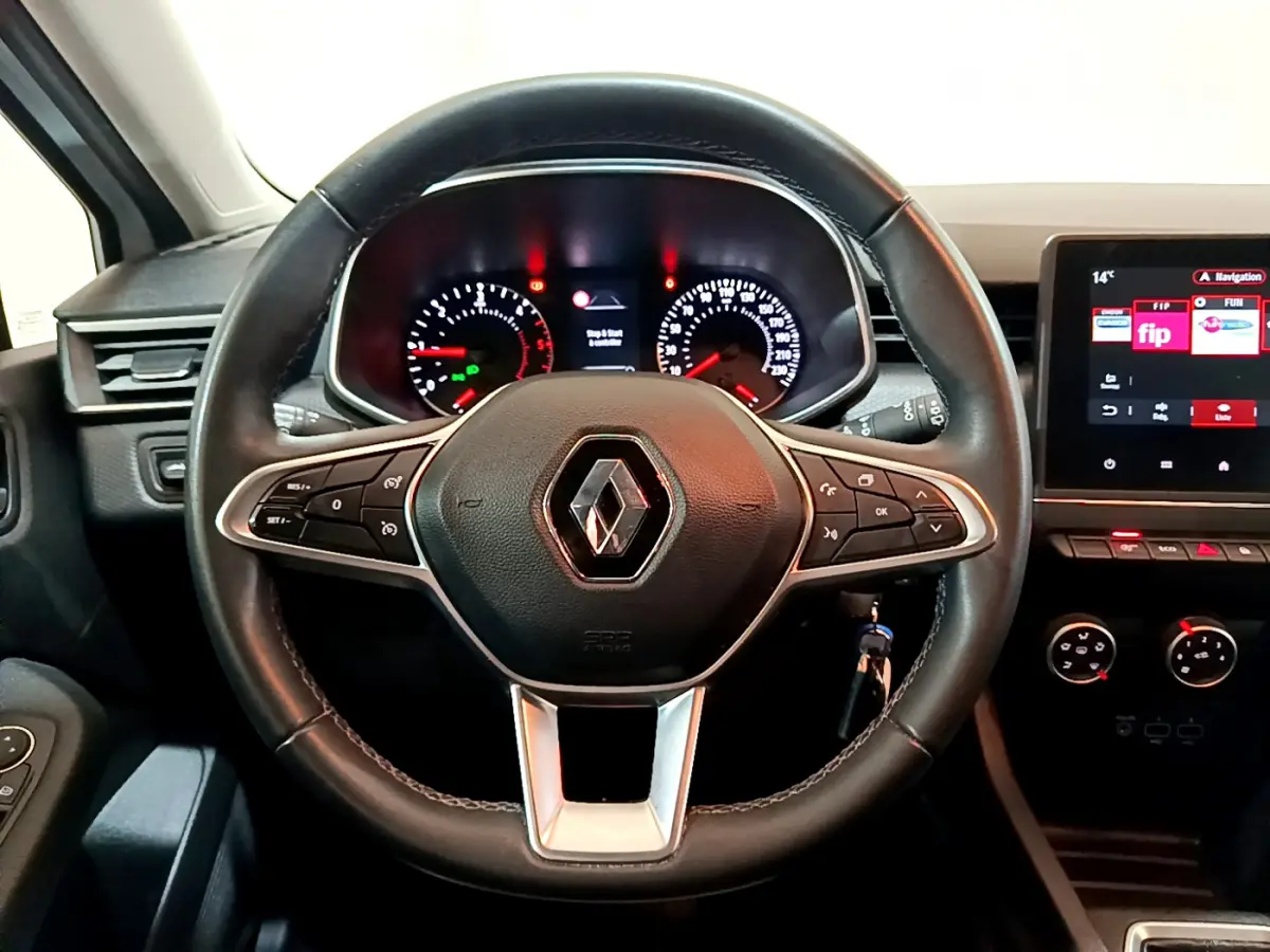 Vue rapprochée du volant cuir noir de la Renault Clio Business avec tableau de bord et écran tactile allumé.