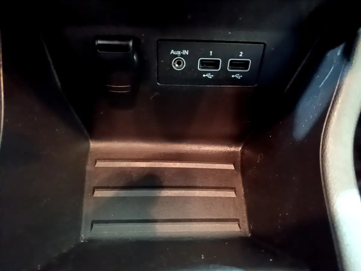 Vue rapprochée des ports USB et prise Aux-IN dans le compartiment central d'une Renault Clio blanche 2020.