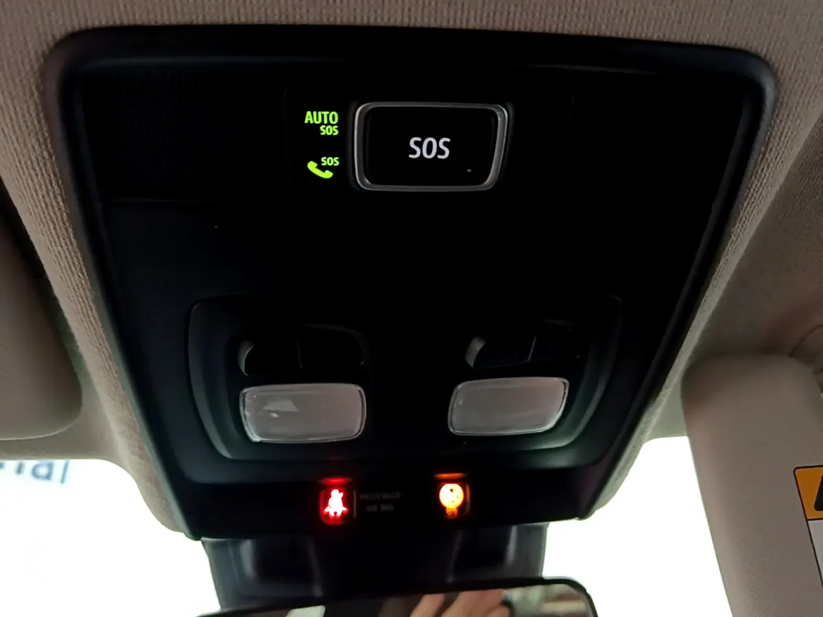 Vue en contre-plongée du plafonnier noir avec bouton SOS et voyants d'alerte dans une Renault Clio blanche 2020.