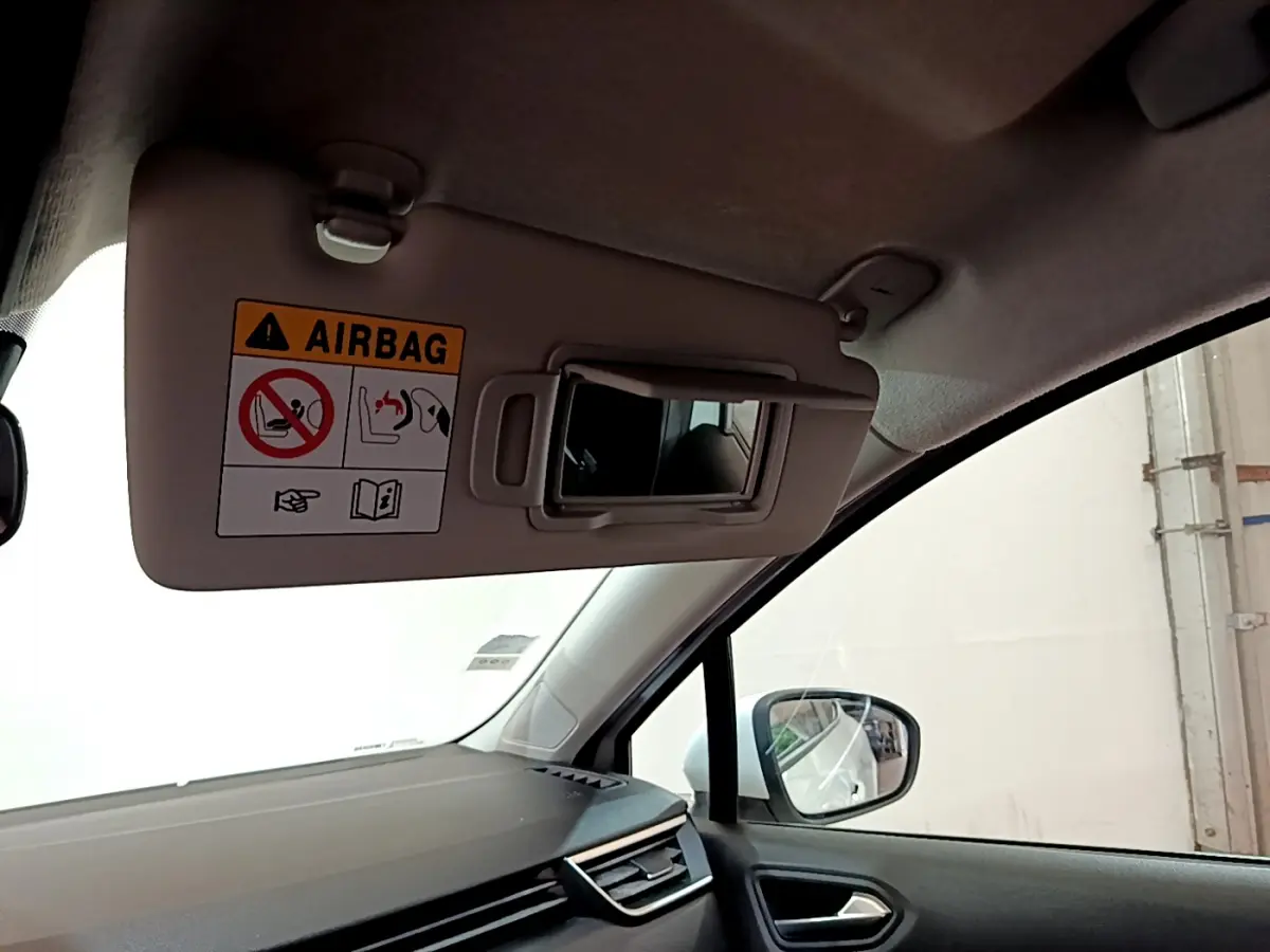 Détail du pare-soleil côté conducteur avec miroir et avertissement airbag dans Renault Clio Business blanc 2020.