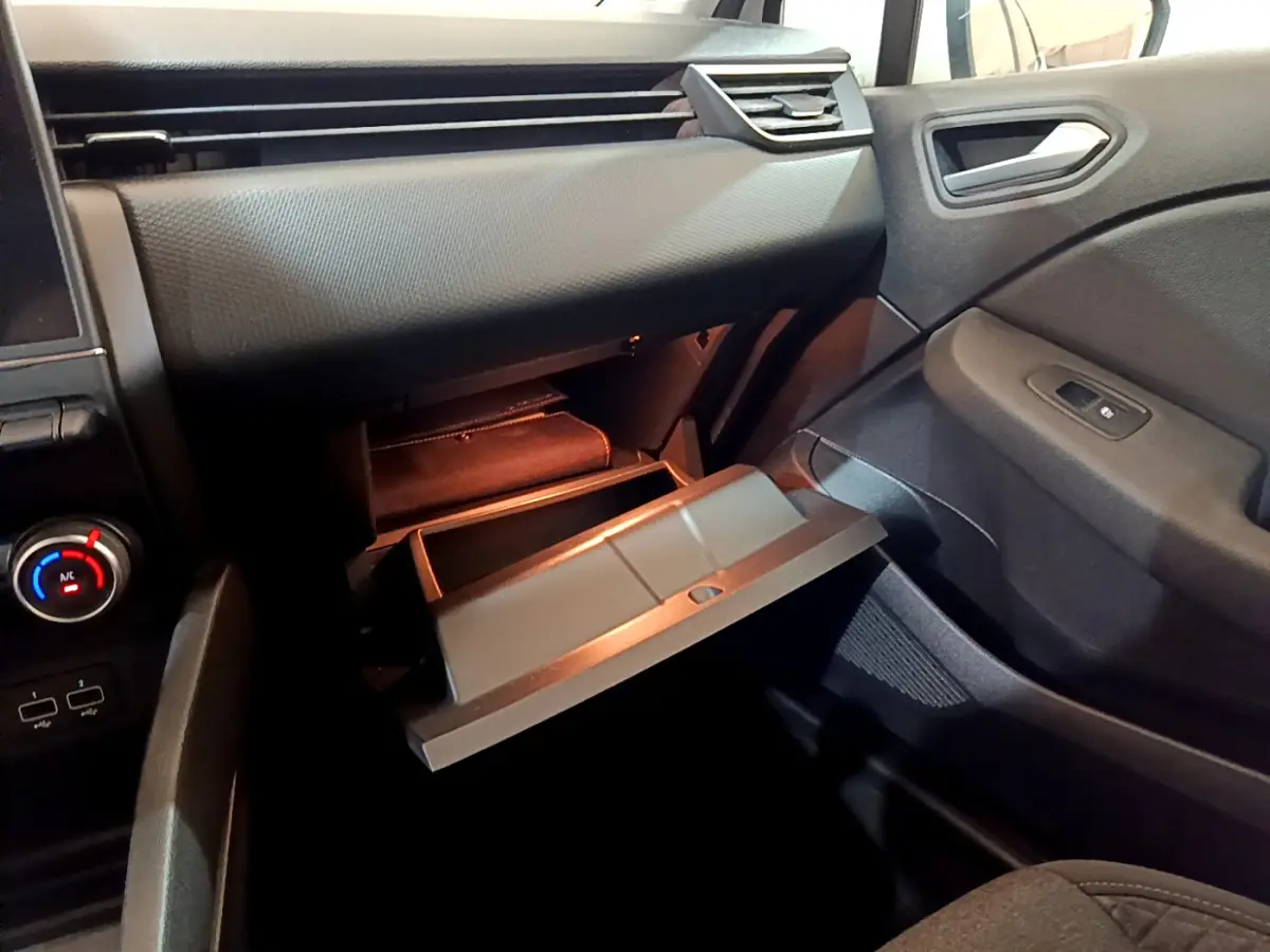 Vue intérieure côté passager de la Renault Clio Business Blue dCi 85 2020, boîte à gants ouverte et tableau de bord noir.
