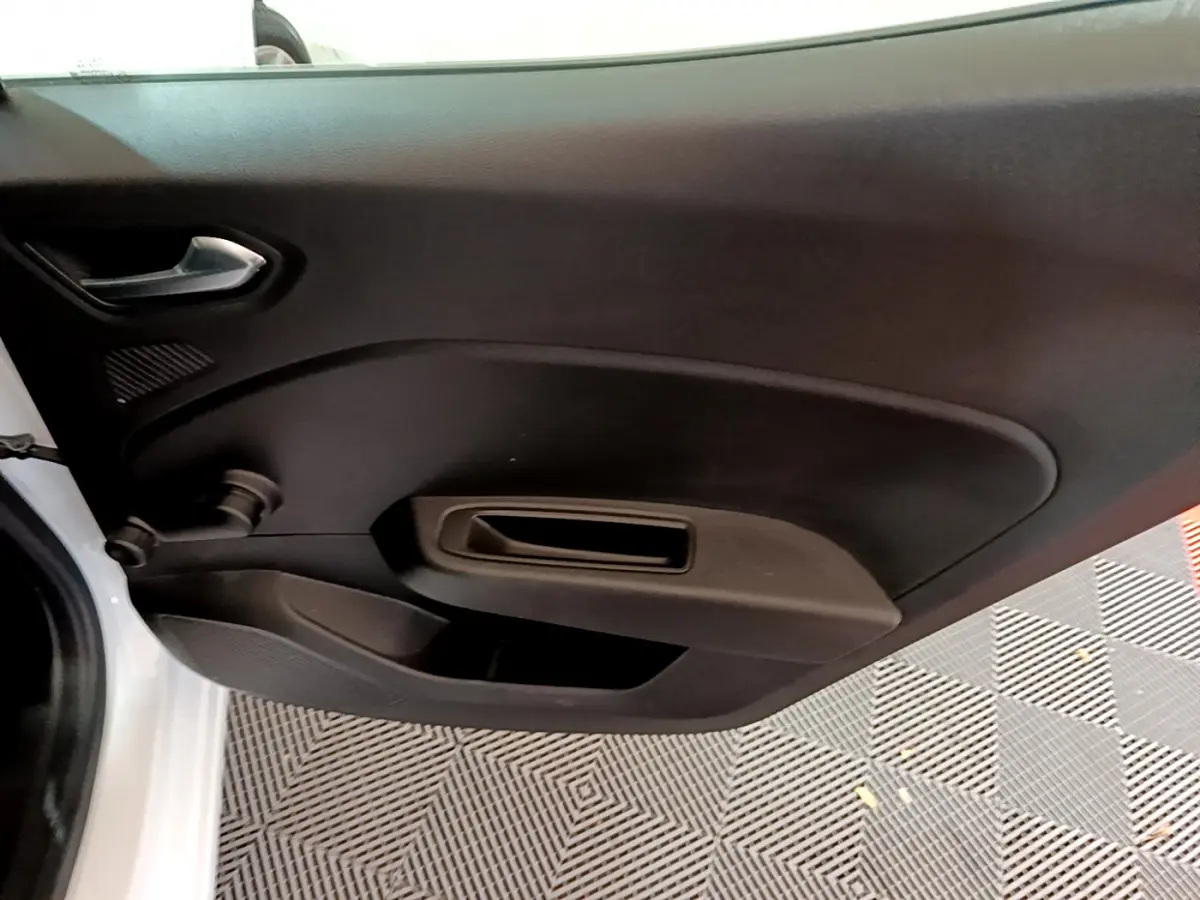 Vue intérieure de la porte côté gauche d'une Renault Clio Business Blue dCi 85 blanche, avec poignée et commande manuelle.