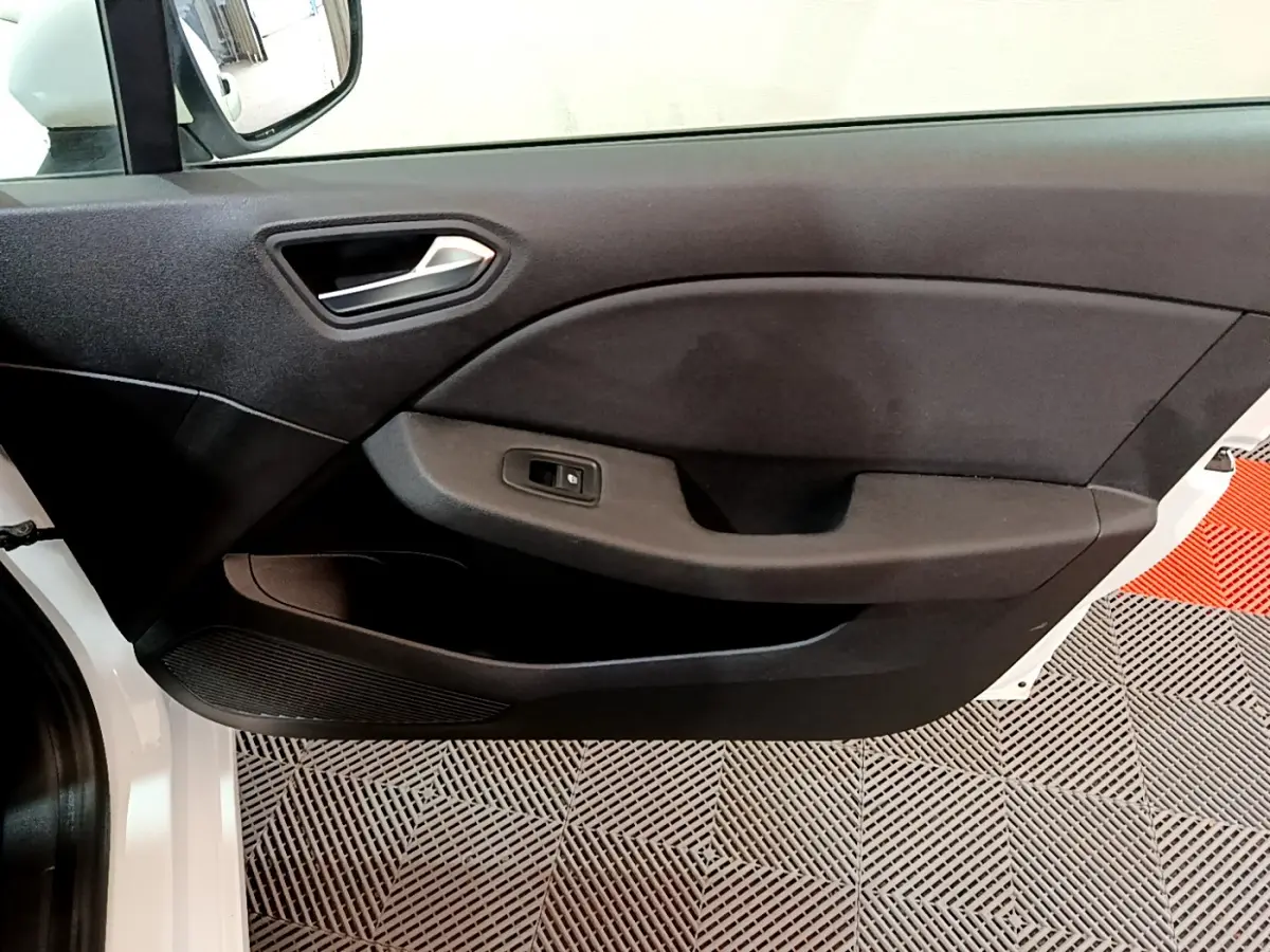 Intérieur montrant la porte avant gauche noire d'une Renault Clio Business Blue dCi 85 blanche, avec poignée et commande vitre.