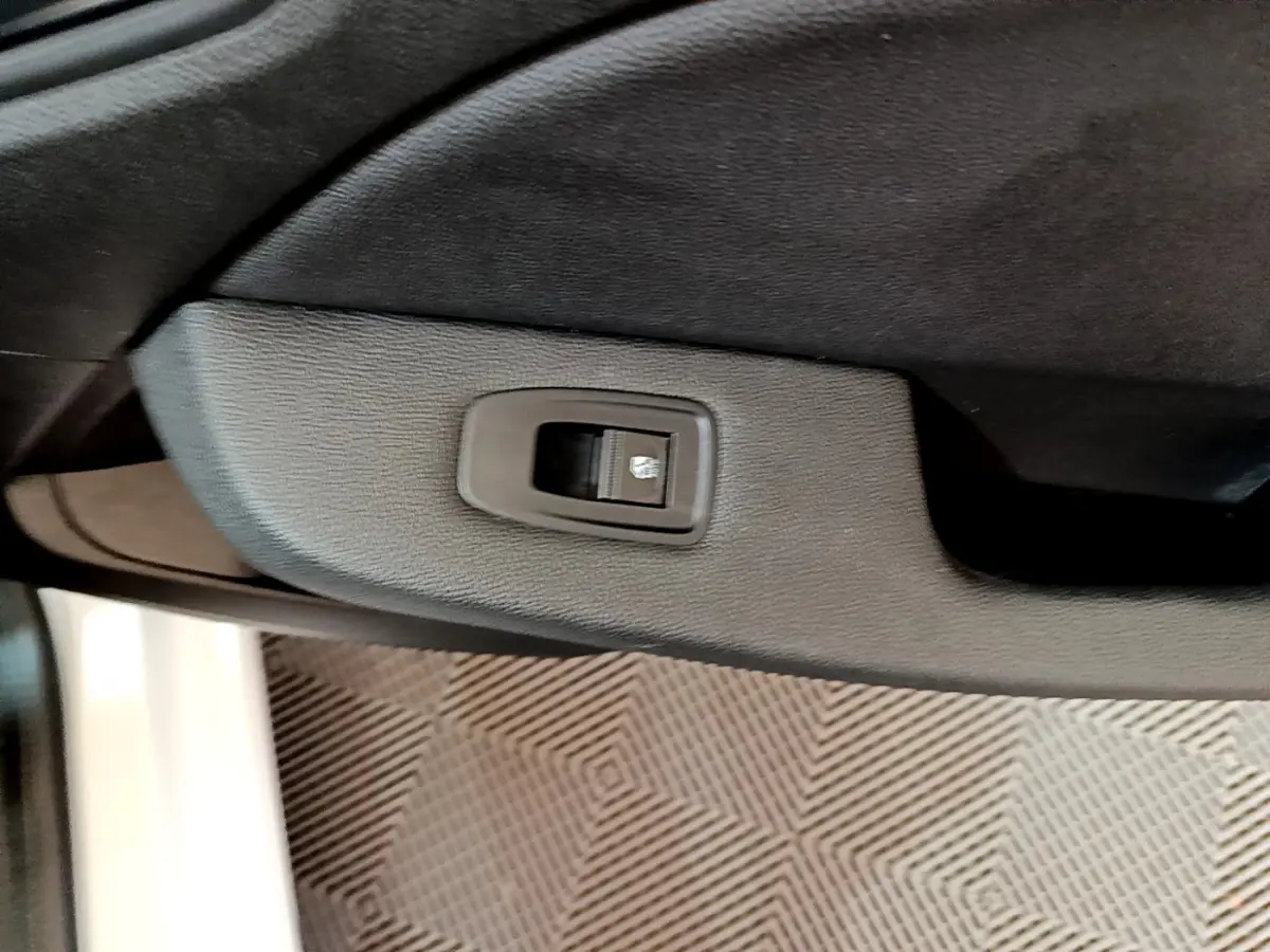 Bouton de commande de lève-vitre sur la porte intérieure côté droit d'une Renault Clio blanche Business Blue dCi 85 2020.