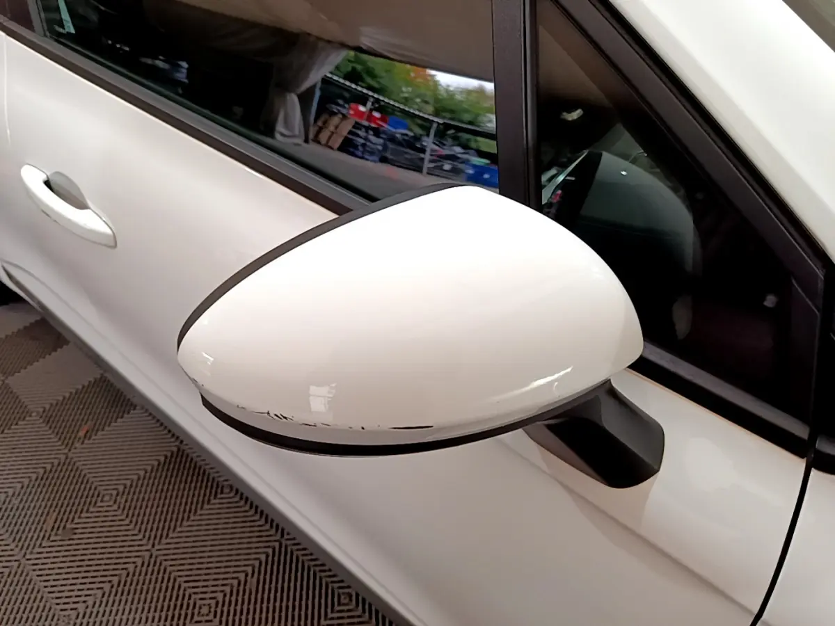 Gros plan sur le rétroviseur côté gauche blanc de la Renault Clio Business Blue dCi 85 blanche avec portière visible.