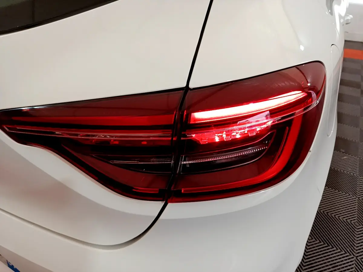 Gros plan sur le feu arrière droit rouge d'une Renault Clio Business Blue dCi 85 blanche de 2020.