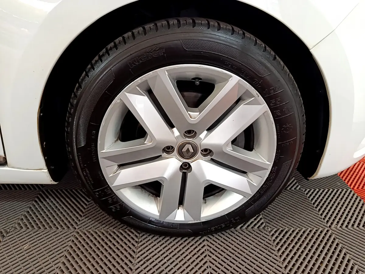 Gros plan sur la roue avant droite blanche d'une Renault Clio Business Blue dCi 85 avec jante alliage argentée.