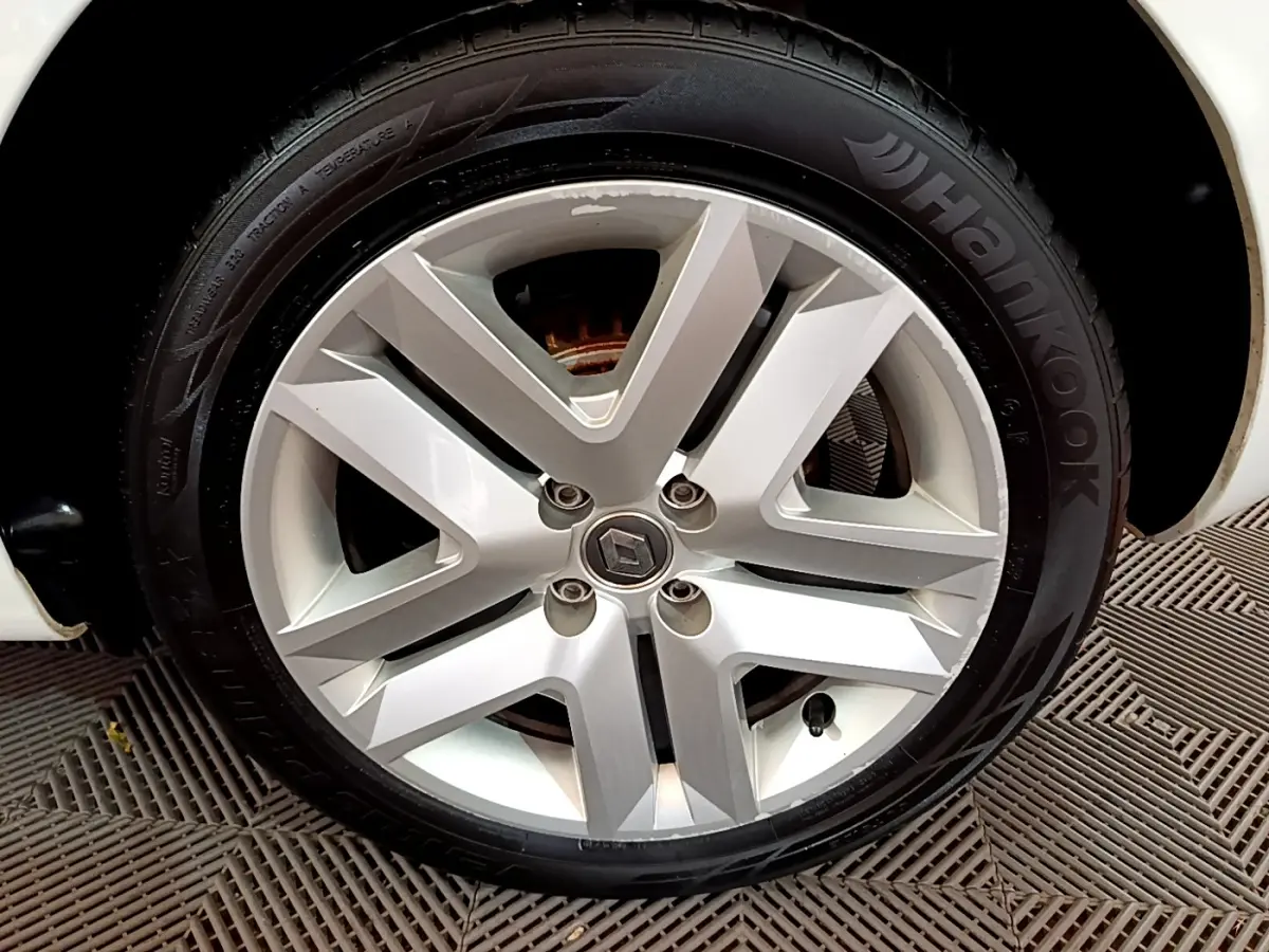 Gros plan sur la roue avant droite blanche d'une Renault Clio Business Blue dCi 85 avec jante alliage moderne.