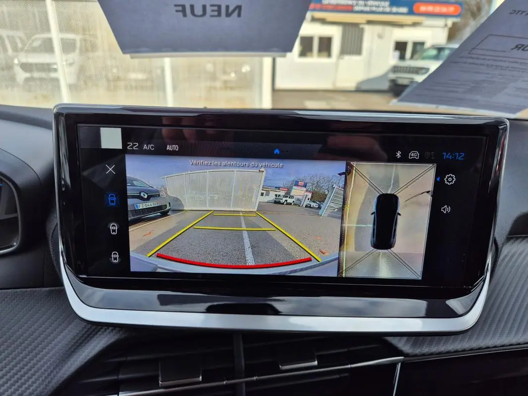 Vue intérieure du tableau de bord de la Peugeot 208 Hybrid blanc, écran tactile affichant la caméra de recul et vue 360°.