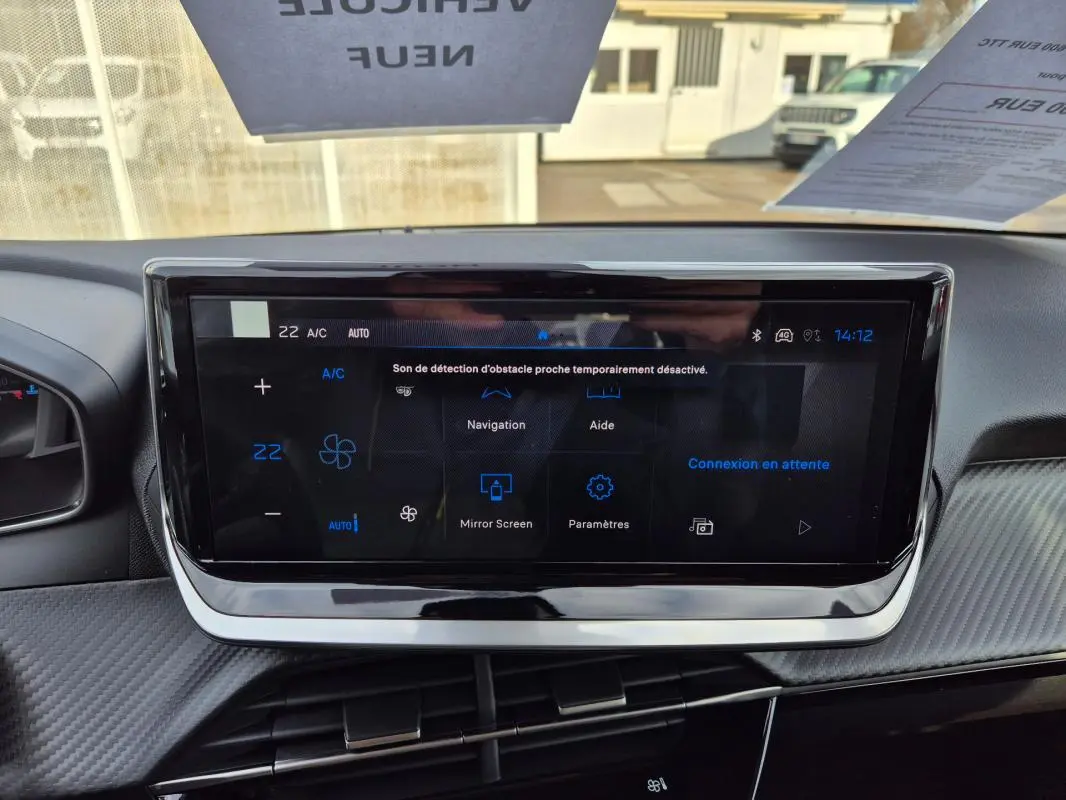 Écran tactile central du tableau de bord de la Peugeot 208 Hybrid blanc, affichant les options de navigation et réglages.