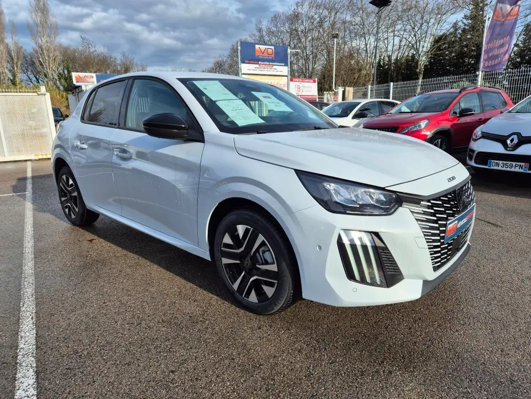 Peugeot 208 Hybrid blanc vue 3/4 avant droit, jantes alliage 16 pouces et feux diurnes verticaux visibles.