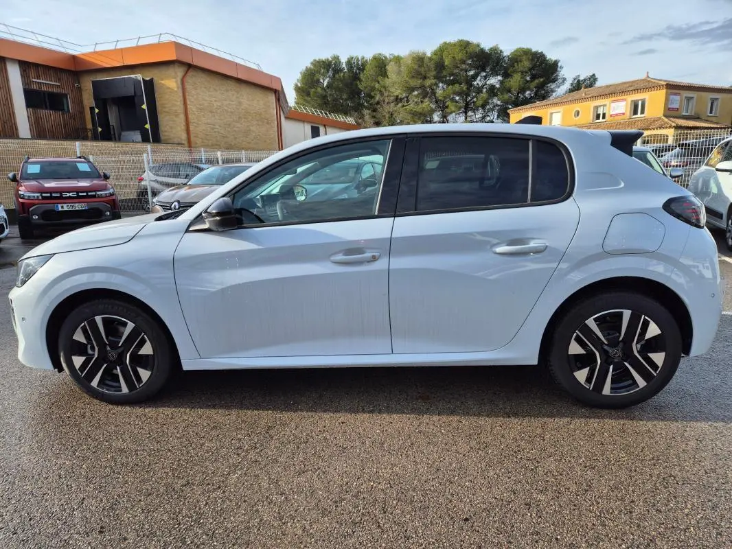 Vue de profil côté gauche d'une Peugeot 208 Hybrid 110 blanche avec jantes alliage noires et détails modernes.