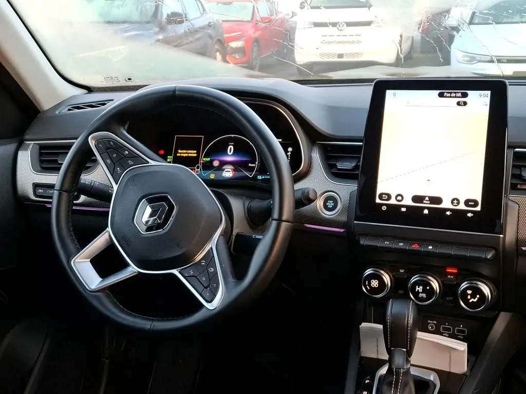 Vue intérieure du tableau de bord et volant de la Renault Arkana 1.6 E-Tech hybride 2023 avec écran tactile vertical et commandes au volant.