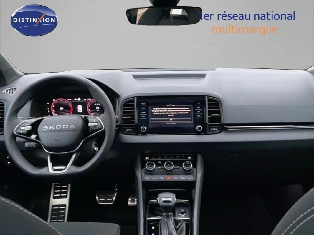 Vue intérieure frontale du tableau de bord et volant cuir multifonctions d'une Skoda Karoq argent 2025, avec écran tactile central.