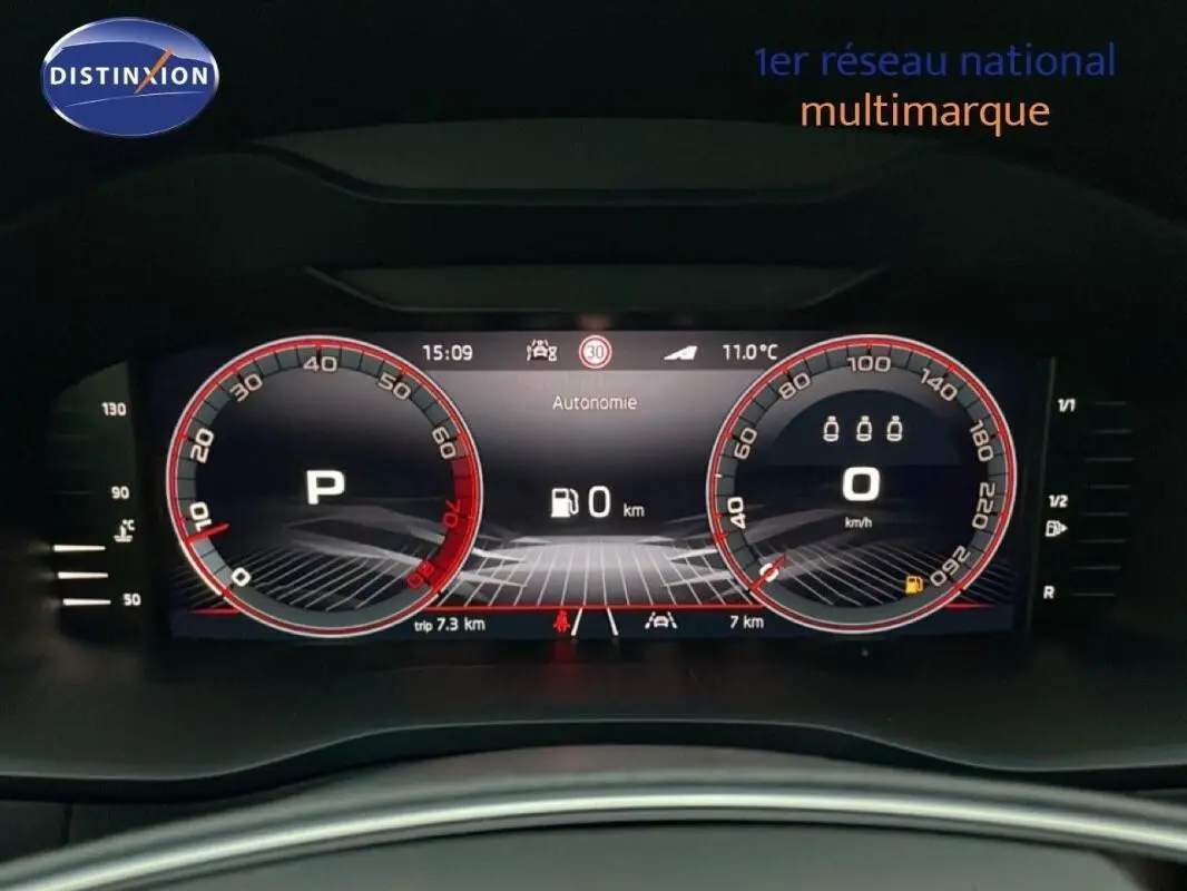 Tableau de bord numérique de la Skoda Karoq argent, affichage vitesse et autonomie à 0 km, vue frontale intérieure.