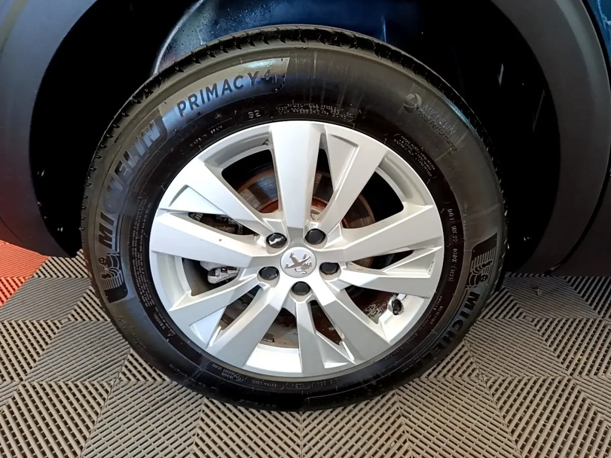Gros plan sur la roue avant droite du Peugeot 5008 bleu, avec jante alliage et pneu Michelin Primacy 4.