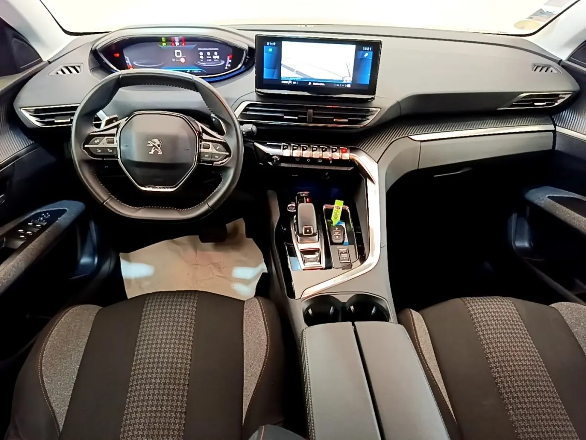 Vue intérieure avant du Peugeot 5008 2021 avec tableau de bord numérique et volant cuir multifonctions noir.