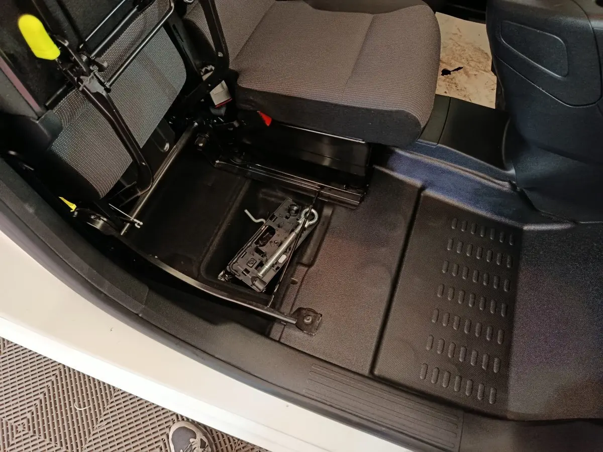 Vue intérieure côté passager du Peugeot Partner blanc 2021, montrant le rangement sous le siège avec outil de roue de secours.