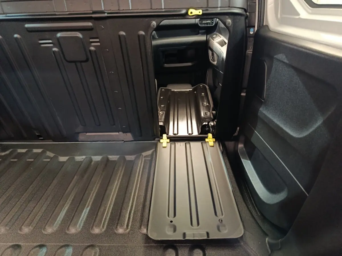 Vue intérieure du coffre du Peugeot Partner blanc 2021, montrant la cloison pleine et le plancher de chargement noir.