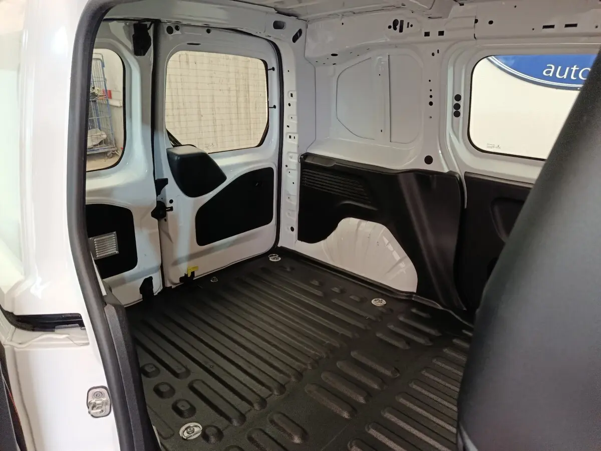 Vue intérieure arrière du Peugeot Partner blanc 2021, montrant l'espace de chargement avec plancher noir antidérapant.