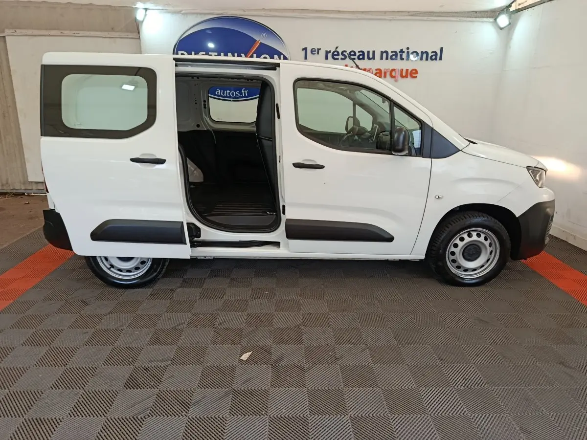 Vue latérale droite d’un Peugeot Partner blanc 2021 avec porte coulissante arrière ouverte, intérieur de chargement visible.