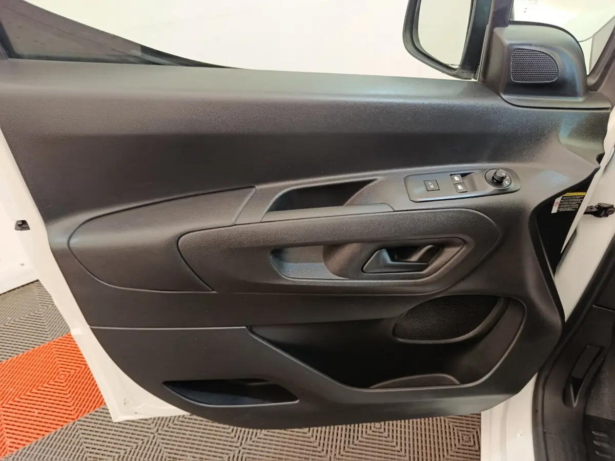 Intérieur côté conducteur du Peugeot Partner blanc 2021, porte avec commandes électriques et haut-parleur intégré.