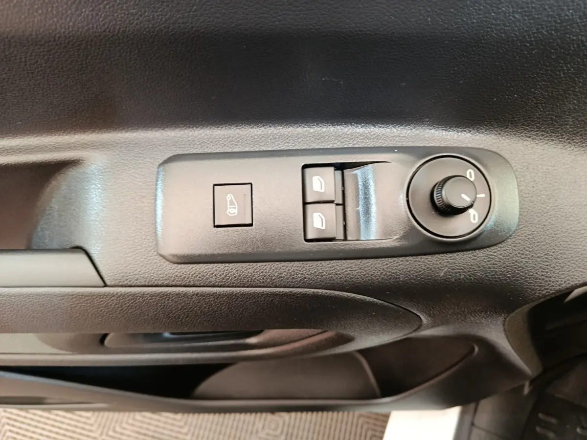 Gros plan sur les commandes de réglage des rétroviseurs et des vitres côté conducteur du Peugeot Partner blanc 2021.