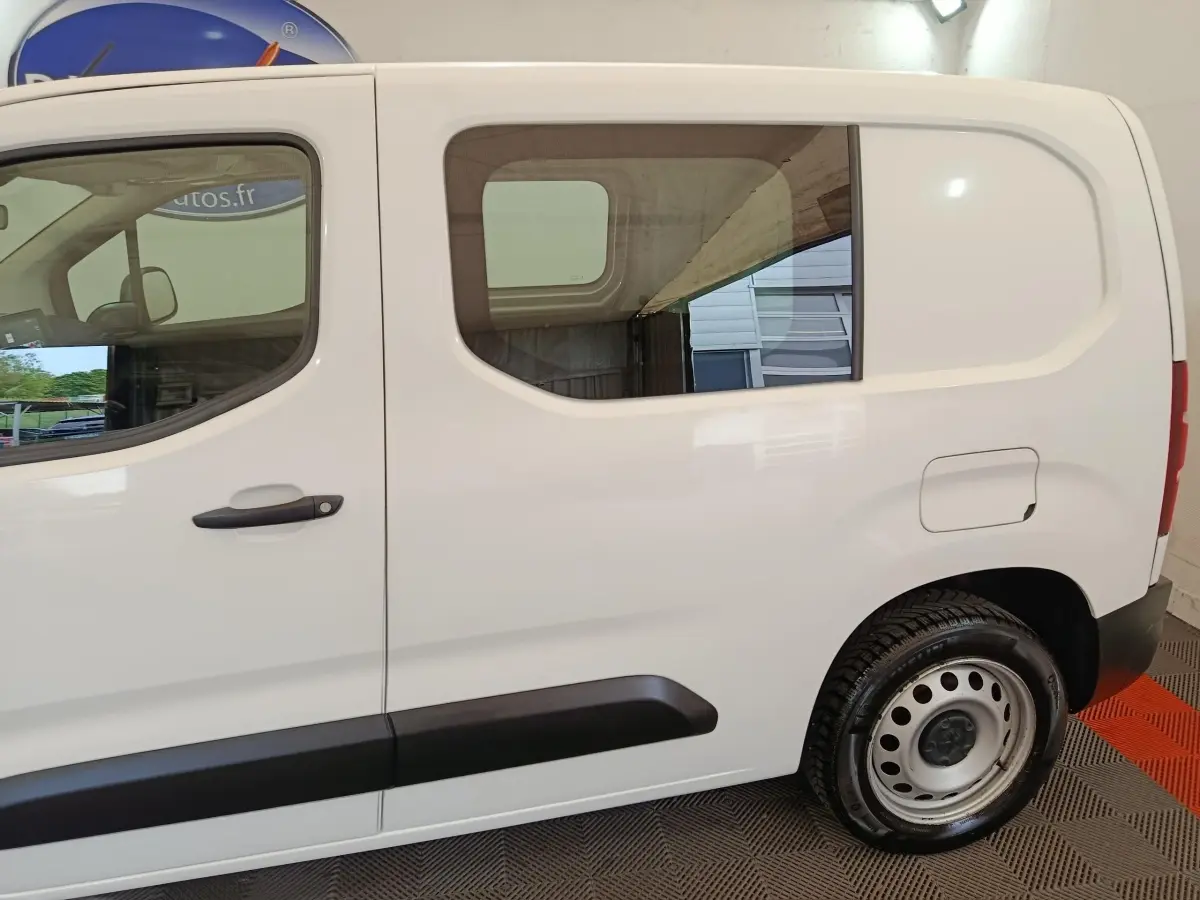 Vue latérale droite du Peugeot Partner blanc 2021 avec fenêtre arrière carrée et jante acier noire.