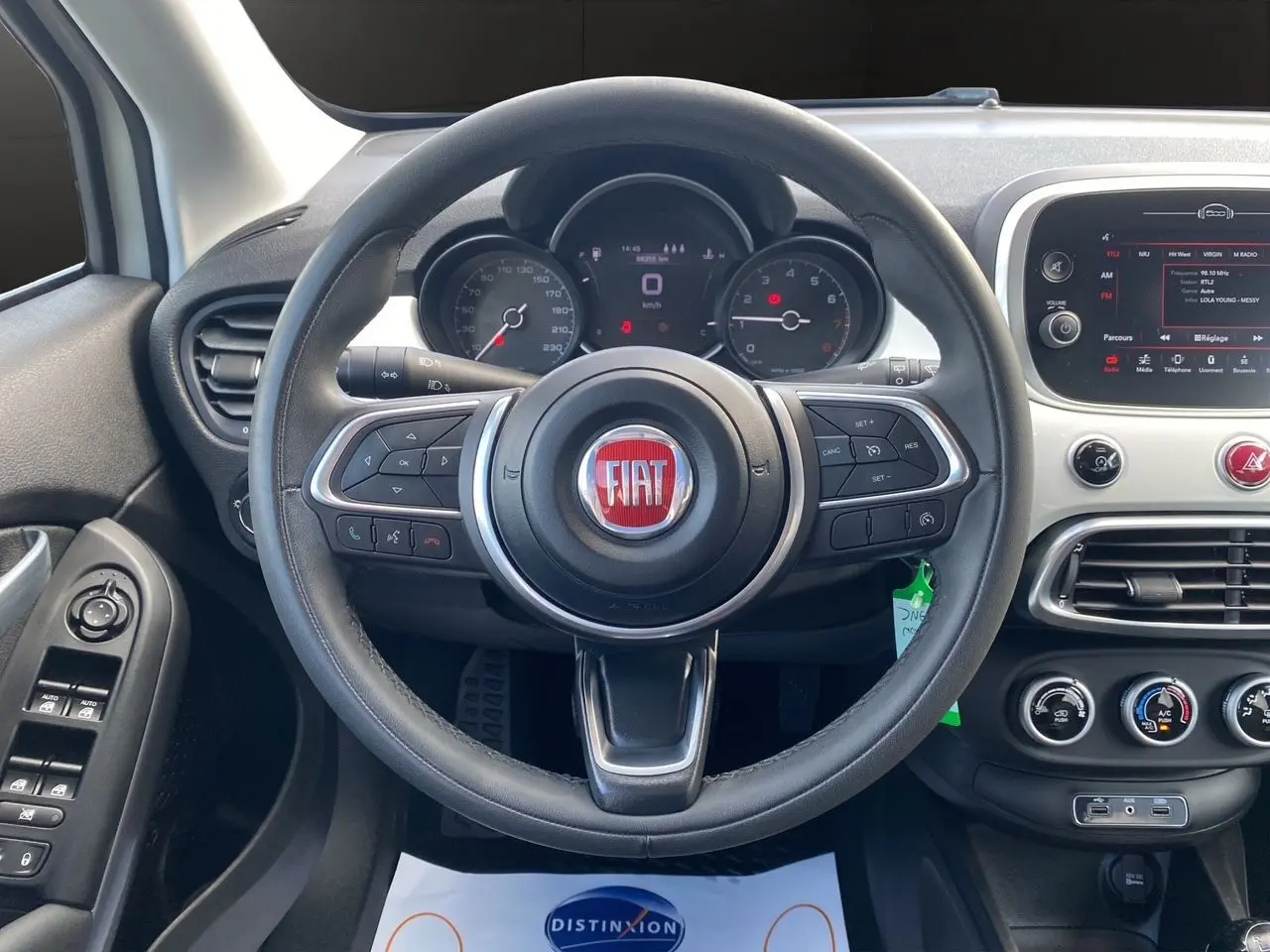 Vue intérieure centrée sur le volant noir de la FIAT 500X 2018 avec tableau de bord et commandes visibles.