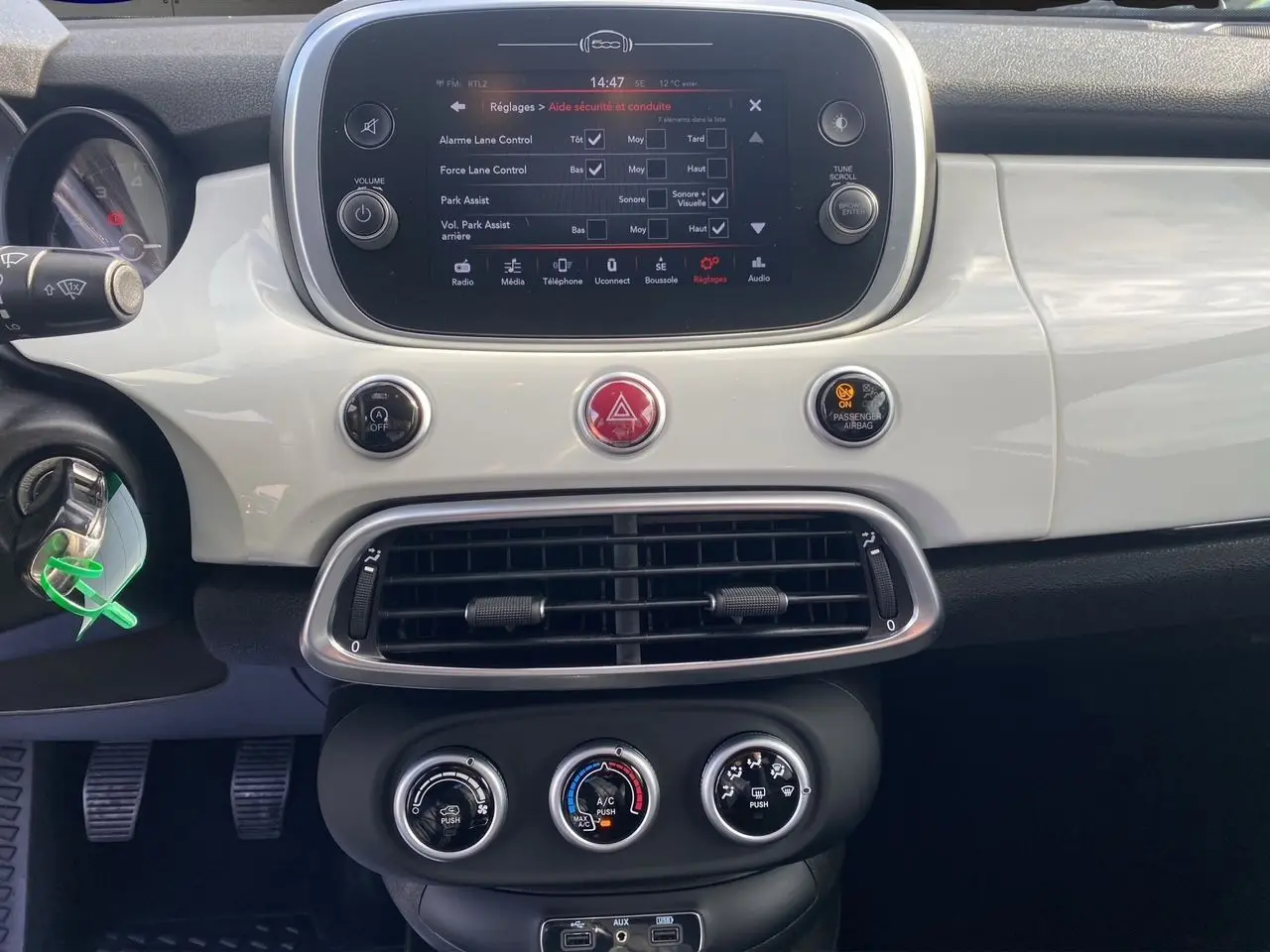 Tableau de bord blanc de la Fiat 500X 2018, vue frontale centrée sur l'écran tactile et commandes climatiques.