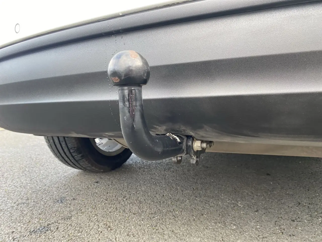 Gros plan sur l'attelage d'une FIAT 500X blanc, visible sous le pare-chocs arrière côté droit.