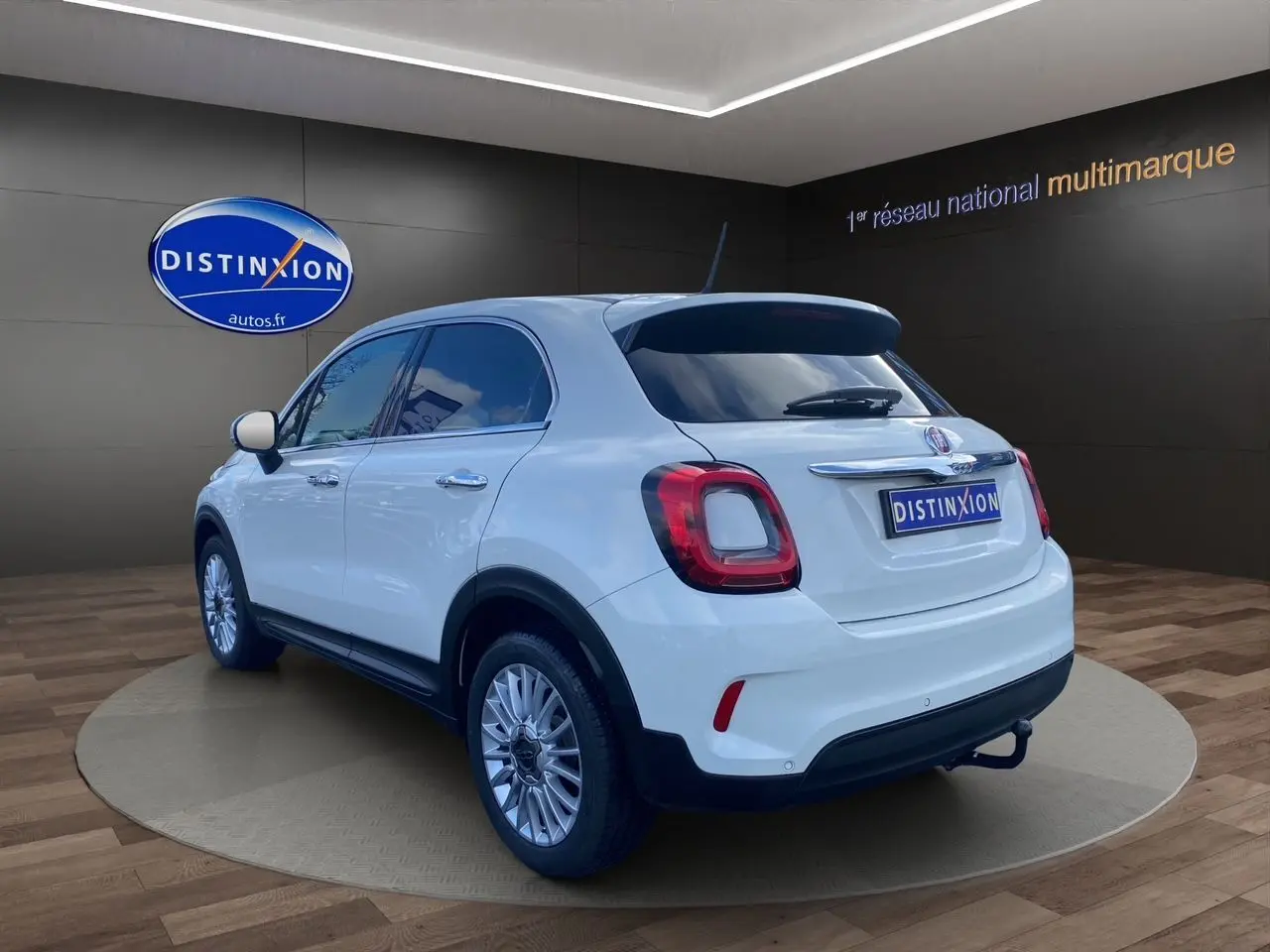 Vue 3/4 arrière droite d'un FIAT 500X blanc avec jantes alliage et feux arrière LED distinctifs.