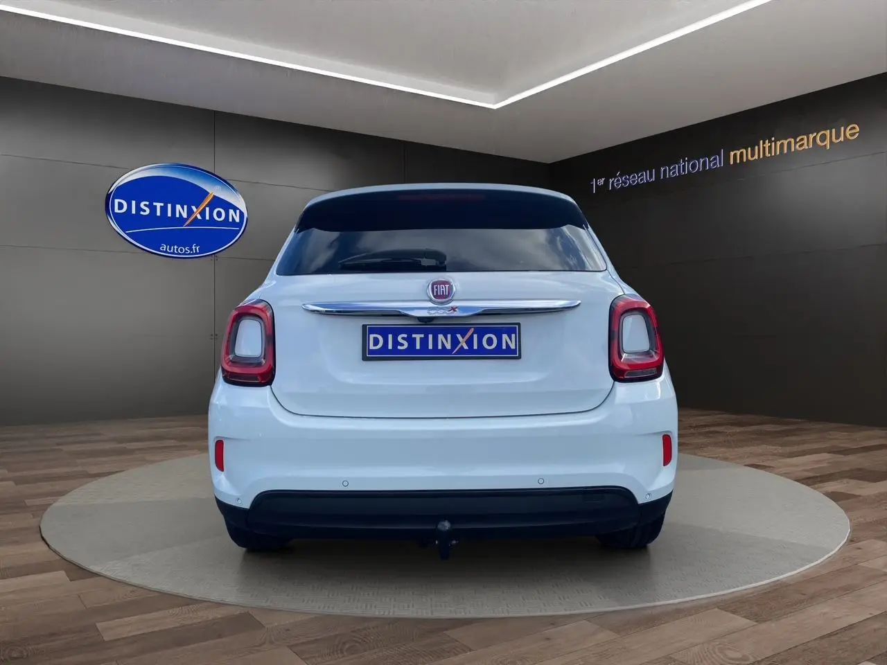 Vue arrière d'une FIAT 500X blanche version Urban Look Opening Edition, avec logo et plaque Distinxion visibles.