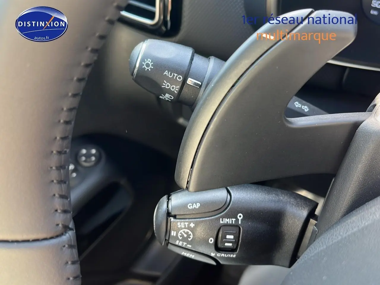 Gros plan sur les commandes au volant du Citroën C5 Aircross 2025 noir, mettant en valeur les fonctions régulateur et limiteur de vitesse.