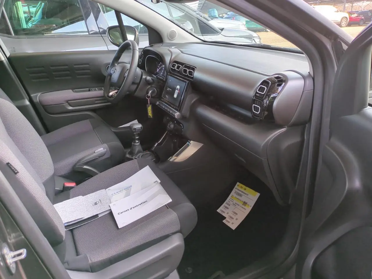 Intérieur côté conducteur du Citroën C3 Aircross gris foncé, montrant tableau de bord et sièges tissu Mica Grey.