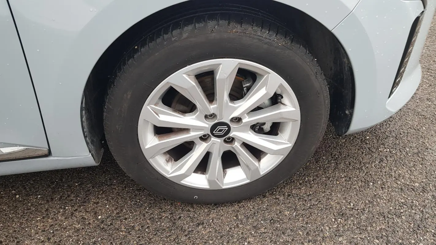 Gros plan sur la roue avant droite gris clair d'une Renault Clio V Blue dCi 2025 avec jante alliage moderne.