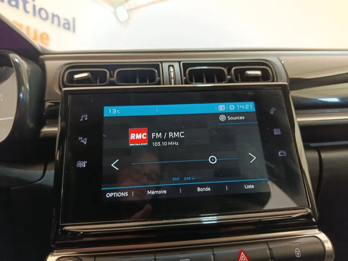 Écran tactile central de la Citroën C3 blanc 2022, vue rapprochée du système multimédia avec radio FM affichée.