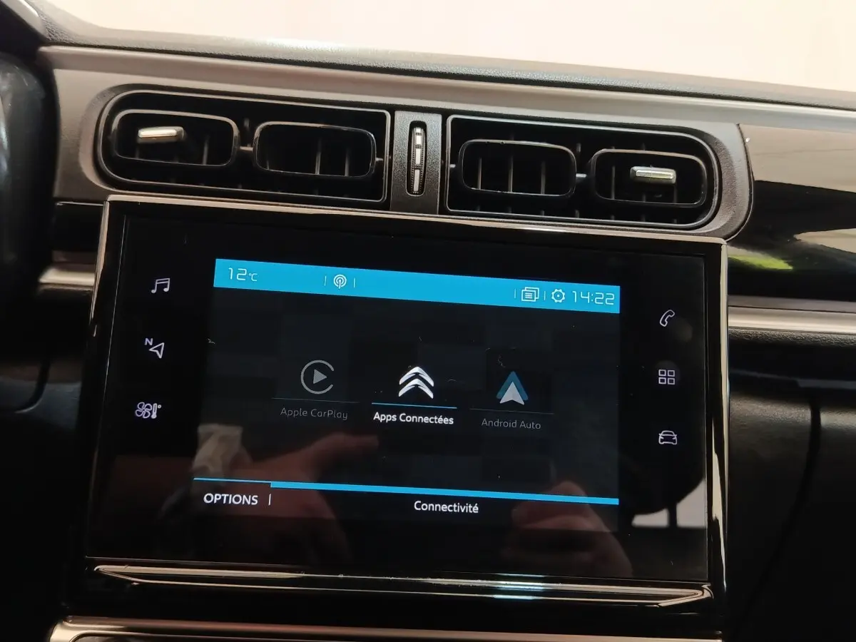 Vue rapprochée de l’écran tactile central noir affichant les options Apple CarPlay et Android Auto dans une Citroën C3 blanche.