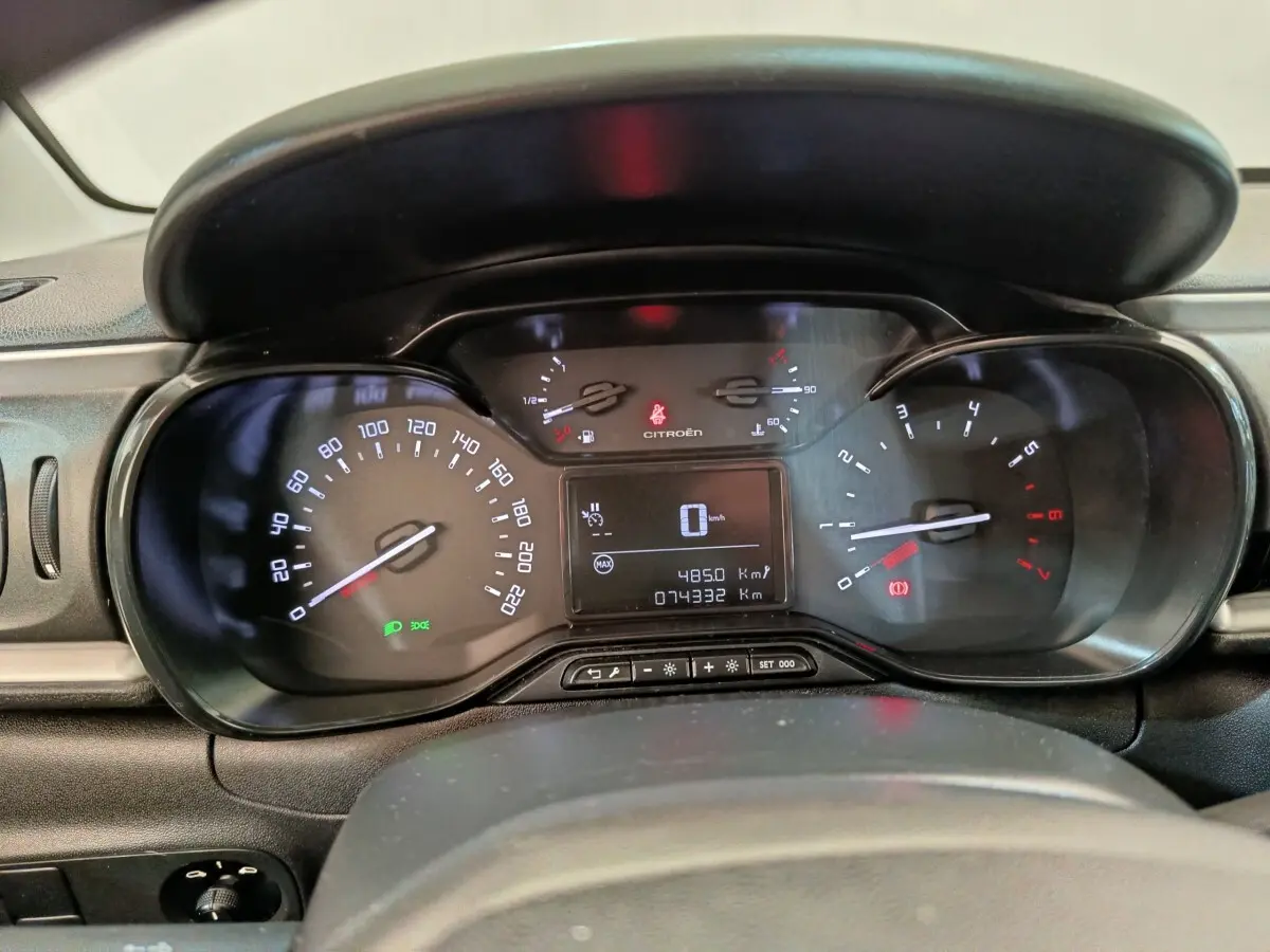 Vue rapprochée du tableau de bord numérique de la Citroën C3 blanche, affichant la vitesse à 0 km/h et les compteurs.