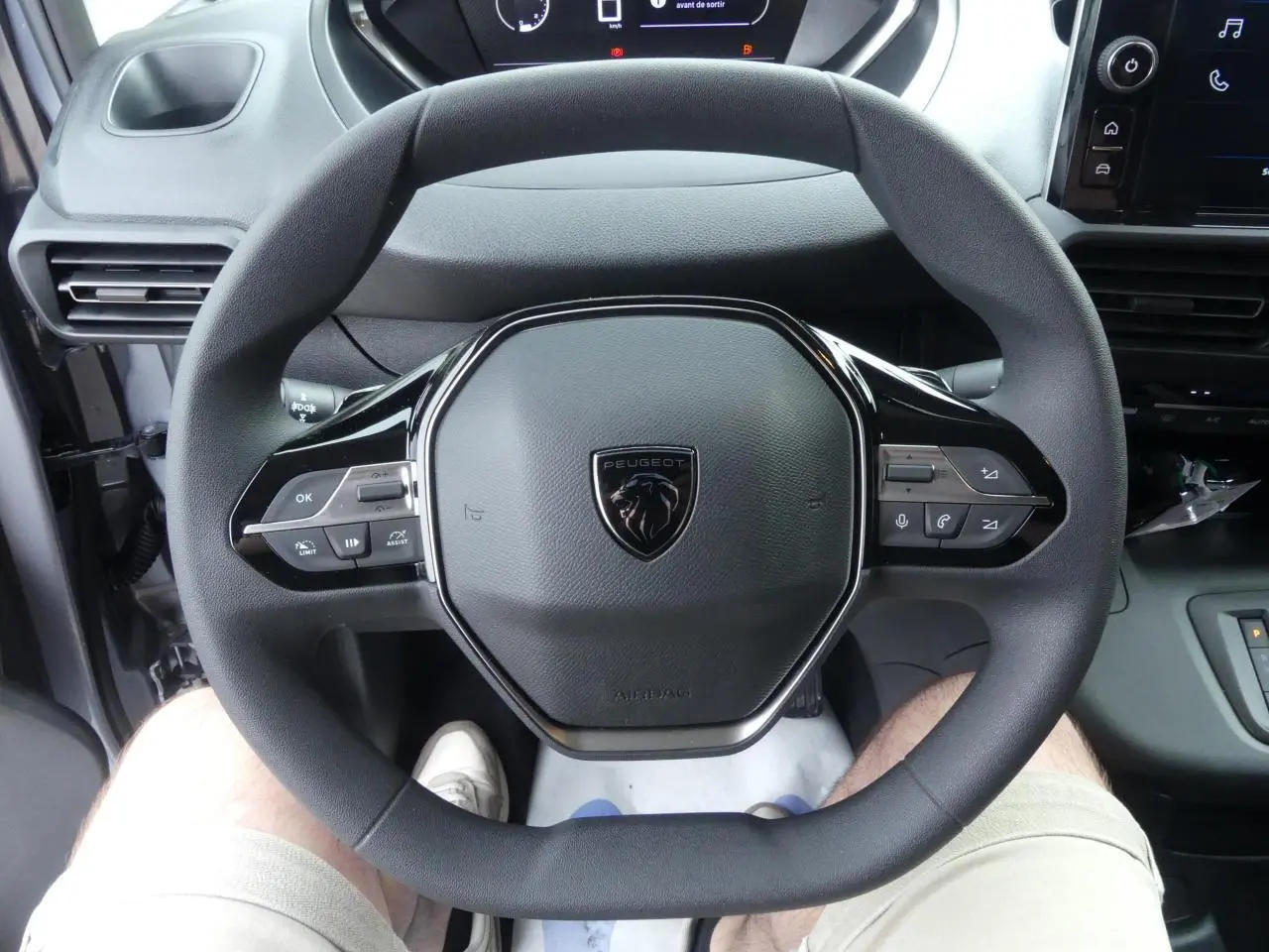 Vue rapprochée du volant multifonctions noir du Peugeot Partner XL 2025 avec tableau de bord et écran tactile visibles.