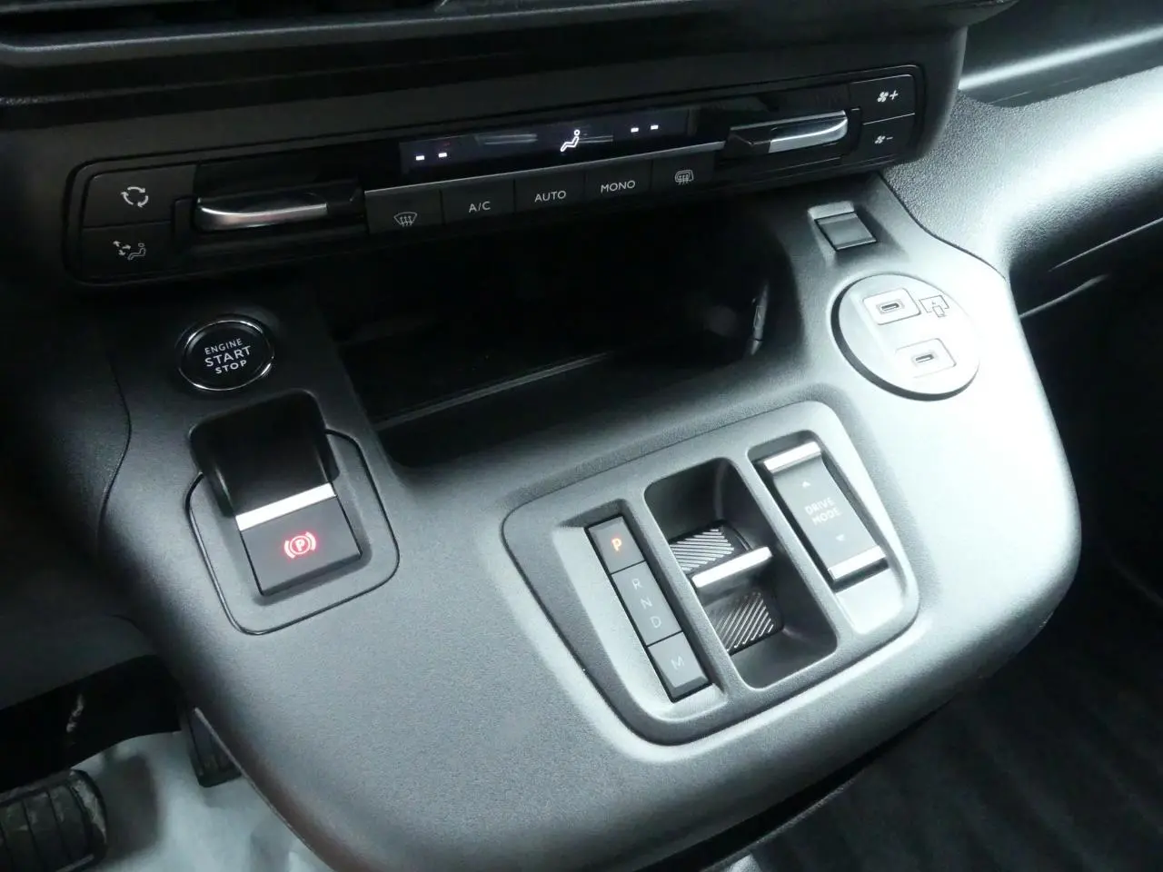 Vue rapprochée de la console centrale du Peugeot Partner 2025 avec boîte auto et commandes de climatisation intégrées.
