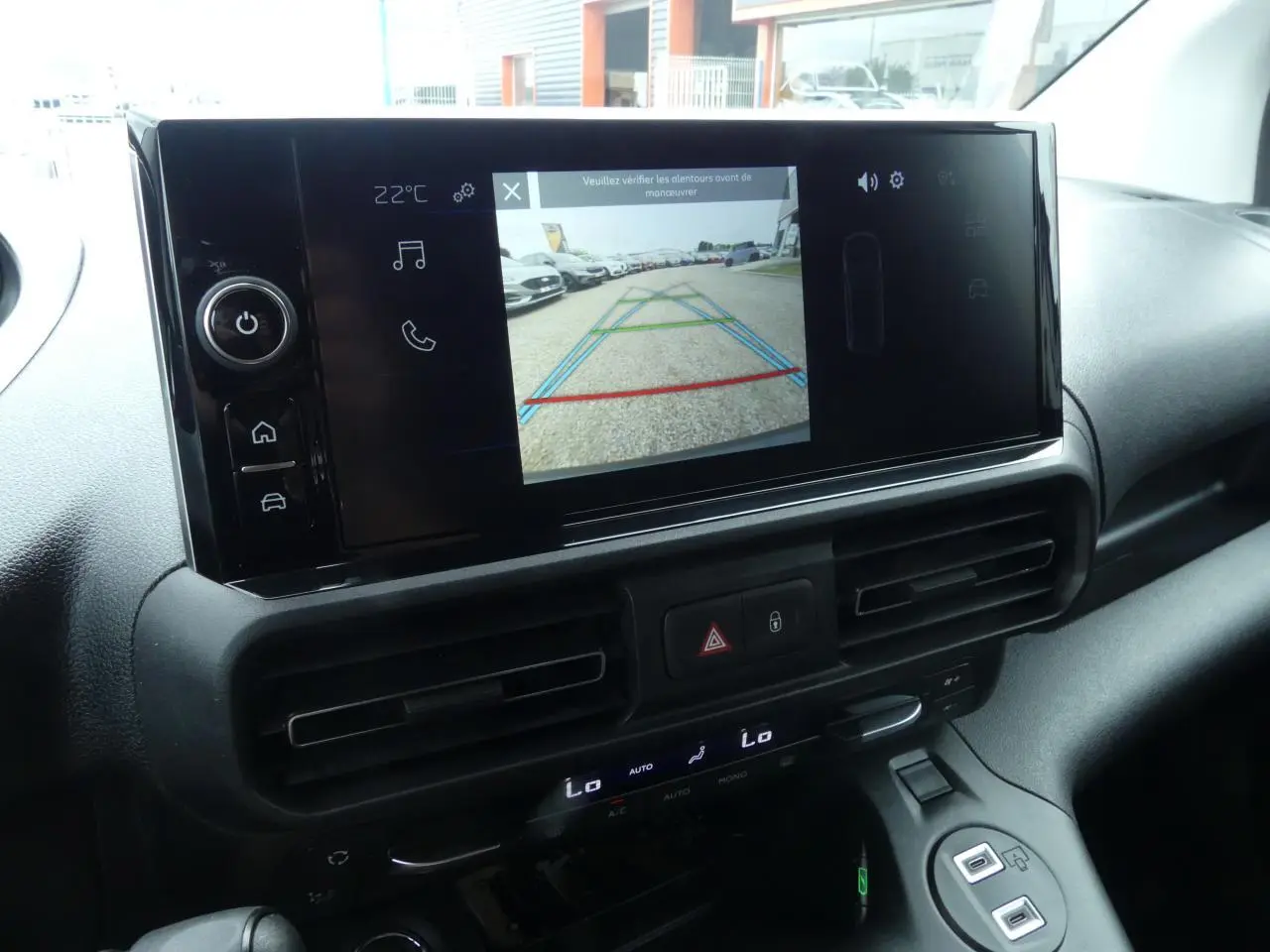 Écran tactile central du Peugeot Partner 2025 montrant la caméra de recul, tableau de bord noir moderne.