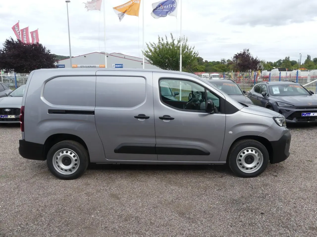 Vue latérale droite d'un Peugeot Partner XL gris métallisé avec portes coulissantes et jantes tôles 16 pouces.