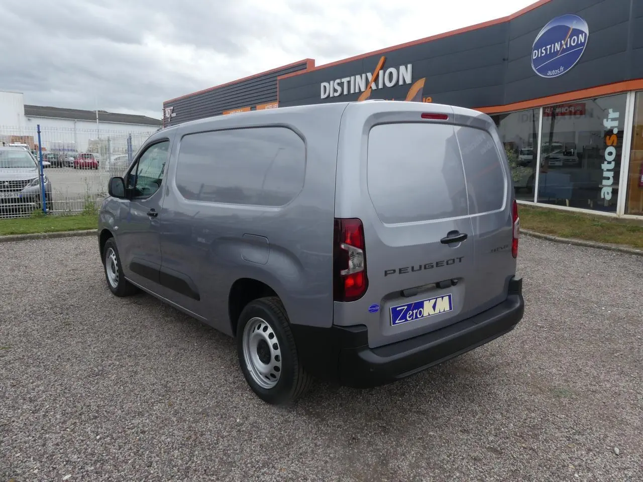Vue 3/4 arrière droite d'un Peugeot Partner XL gris métallisé avec portes arrière battantes et jantes tôles grises.