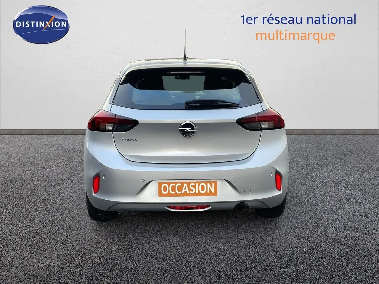 Vue arrière d'une Opel Corsa gris kristall metal 2022 avec feux rouges et plaque d'immatriculation "OCCASION" visible.