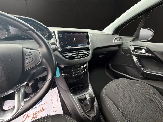 Vue intérieure avant droite de la Peugeot 208 gris platinium, volant cuir multifonctions et écran tactile 7 pouces.