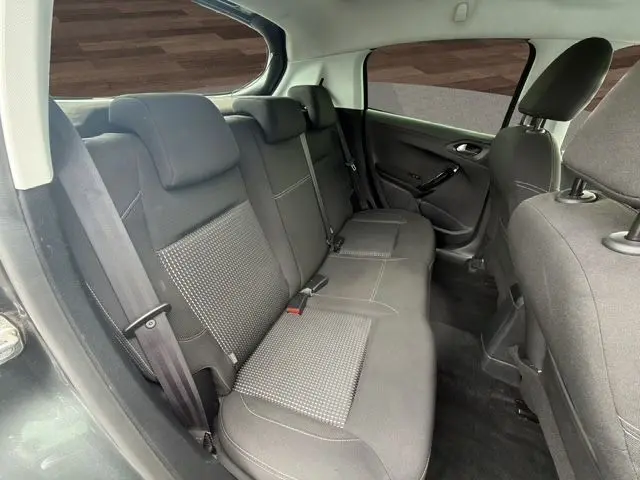 Vue intérieure arrière côté gauche de la banquette tissu gris foncé de la Peugeot 208 gris platinium, avec ceinture de sécurité visible.