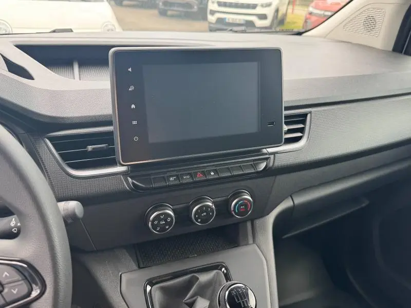 Vue intérieure côté passager du tableau de bord noir du Renault Kangoo Van 2024 avec écran tactile et commandes de climatisation.
