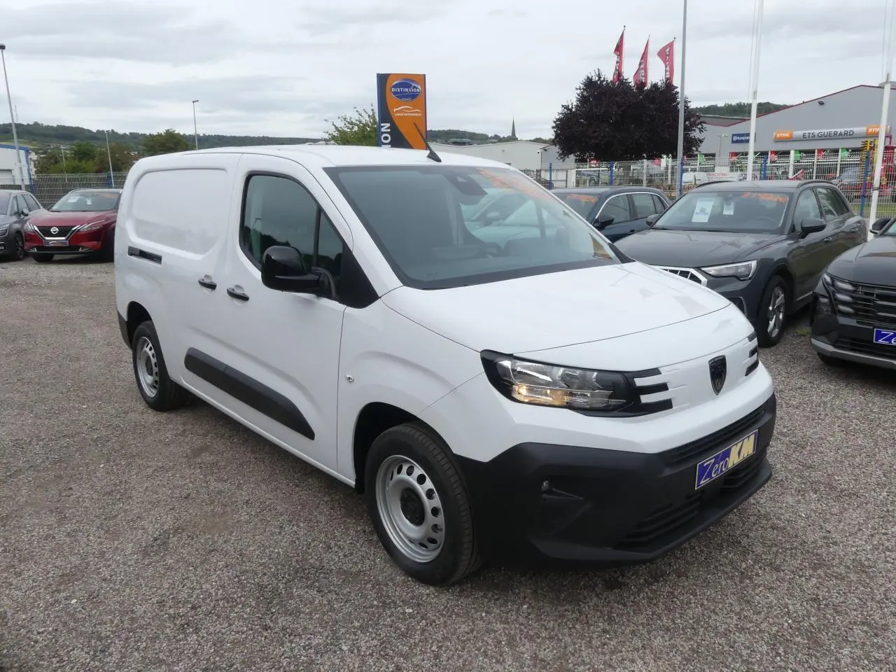 Peugeot Partner XL blanc vu en 3/4 avant droit avec boucliers noirs et jantes tôles grises