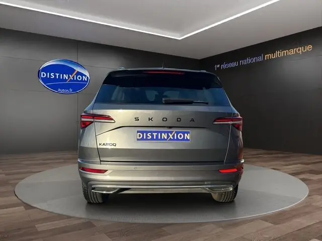 Vue arrière d'un Skoda Karoq gris graphite 2025 avec feux arrière LED et attelage escamotable visible.
